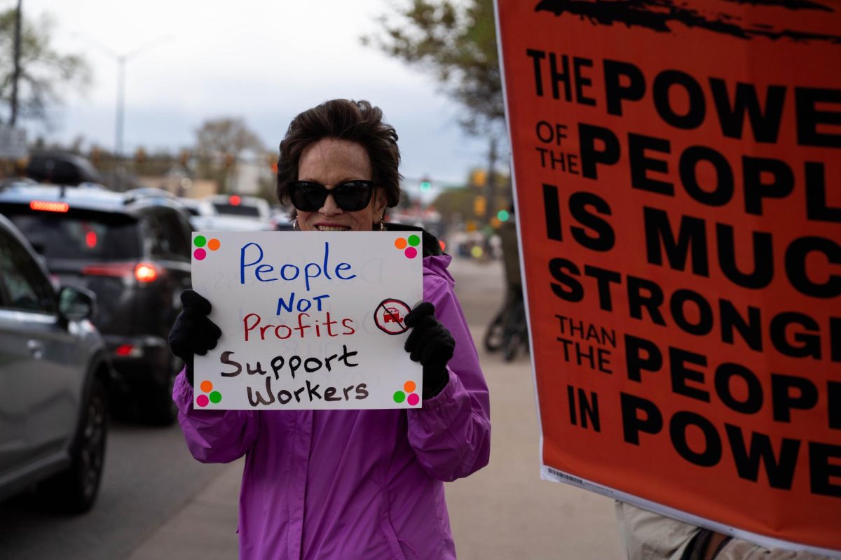 Barbra, a protestor who only provided her first name, holds a sign to passing cars on College Ave.  Part of the May Day protests, a nation-wide movement protesting recent federal actions, Fort Collins residents lined College Ave.  