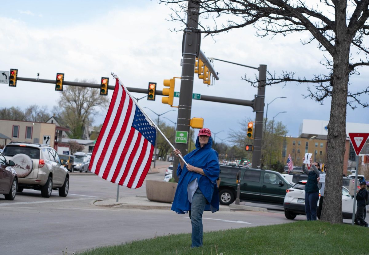 A protestor holds an upside down American flag on the corner of College Ave. and Prospect Road May 1.  Part of the May Day protests, a nation-wide movement protesting recent federal actions, Fort Collins residents lined College Ave.  