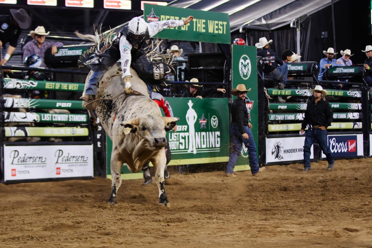 A pro bull rider holds on tight during his ride at the PBR Last Cowboy Standing Event on July 21, 2025 in Fort Collins Colorado at Canvas Stadium. Photo taken by Erica Pickering.