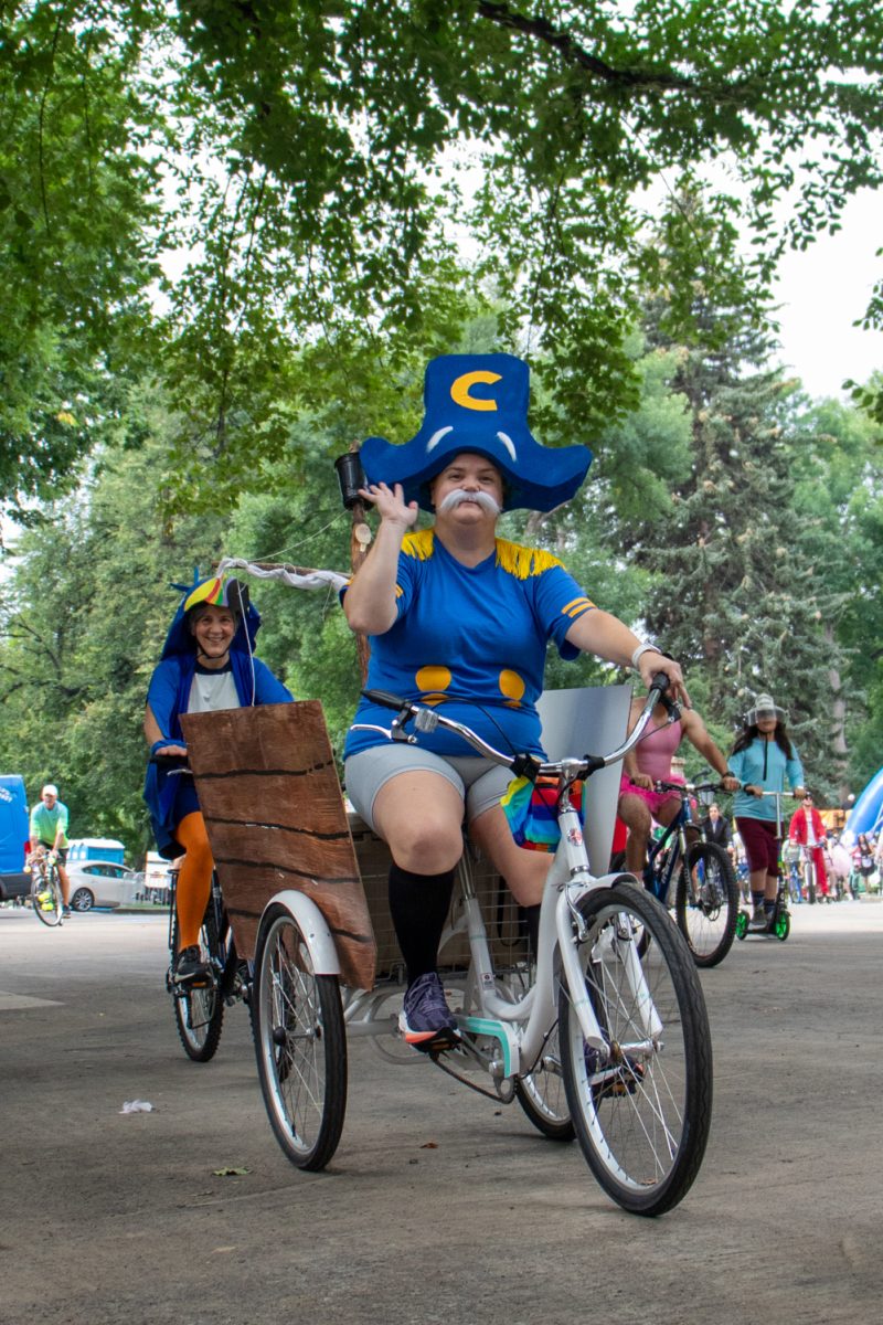 A participant dressed as Cap'n Crunch
waves and rides their bike during the Tour de Fat parade Aug. 23.