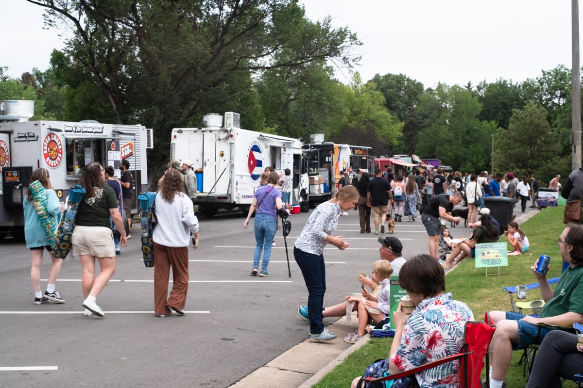 Members of the Fort Collins community walk in City Park next to a long row of food trucks and sit in the nearby grass, enjoying food at the weekly FOCO Food Truck Rally Aug. 26.