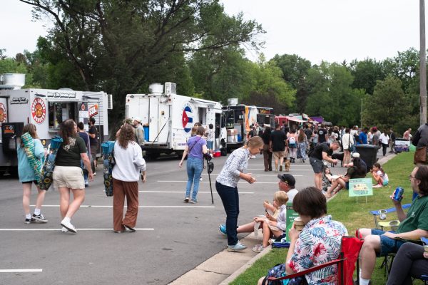Members of the Fort Collins community walk in City Park next to a long row of food trucks and sit in the nearby grass, enjoying food at the weekly FOCO Food Truck Rally Aug. 26.
