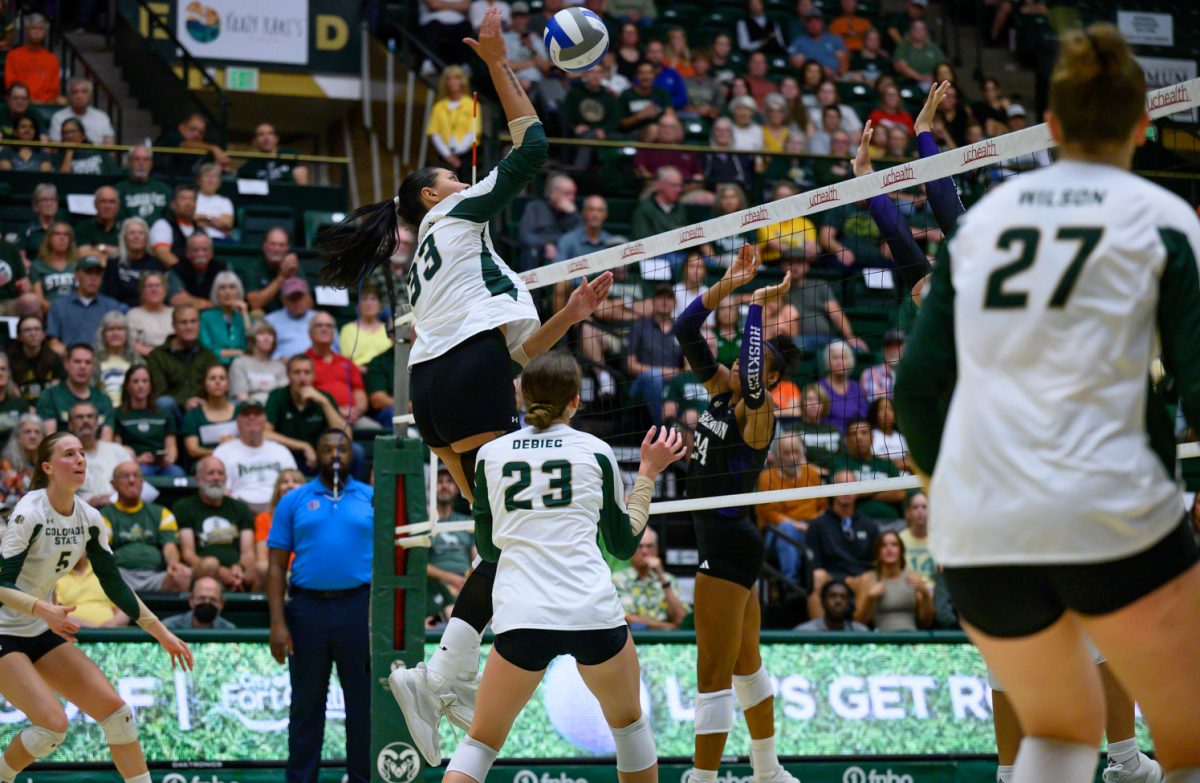 Middle blocker Kekua Richards (33) hits the ball over the net to during Colorado State University's game against the University of Washington Aug. 30. CSU lost 2-3.