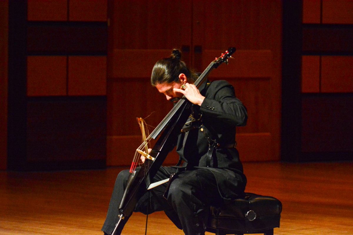 A man playing his cello on stage.
