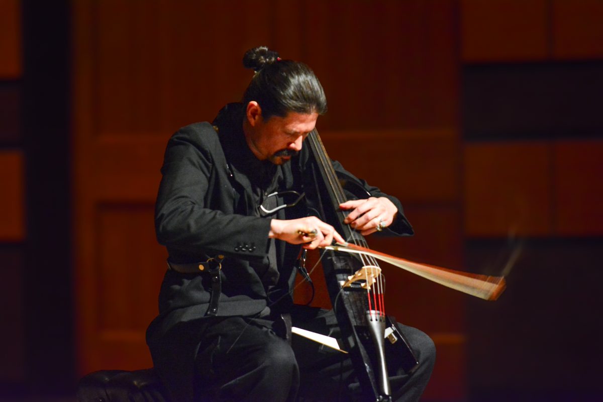 A man playing his cello on stage.