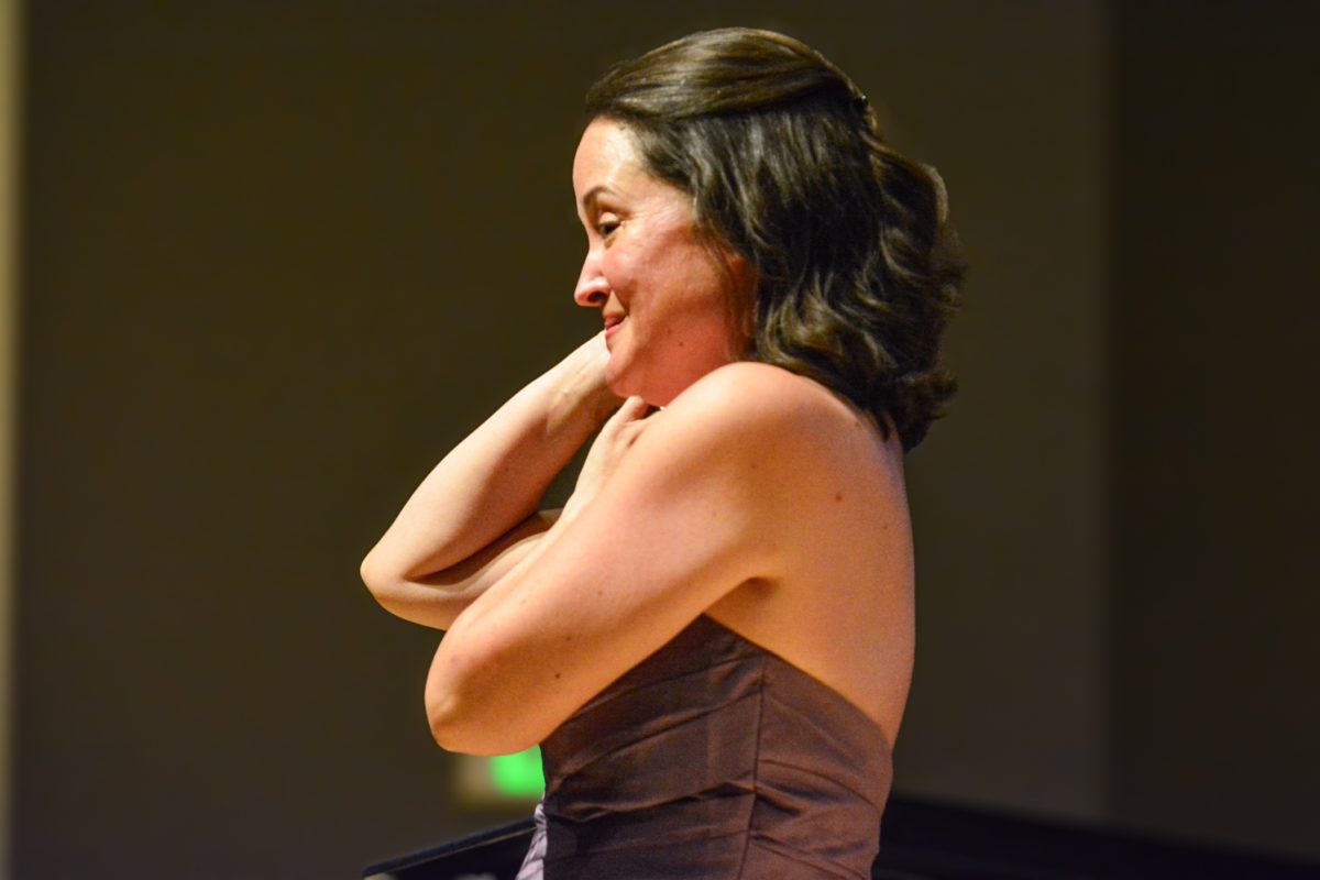 A woman smiling to the crowd.