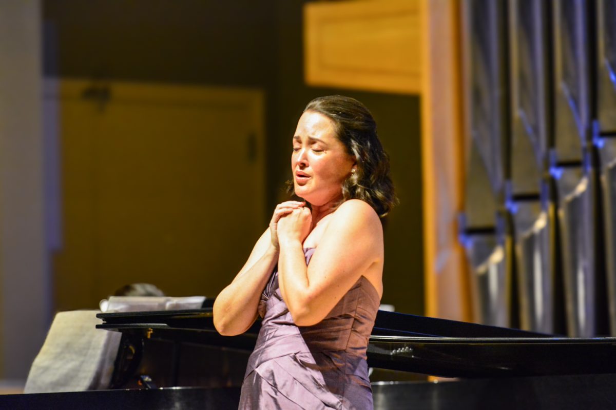 A woman singing to the crowd with her eyes closed.