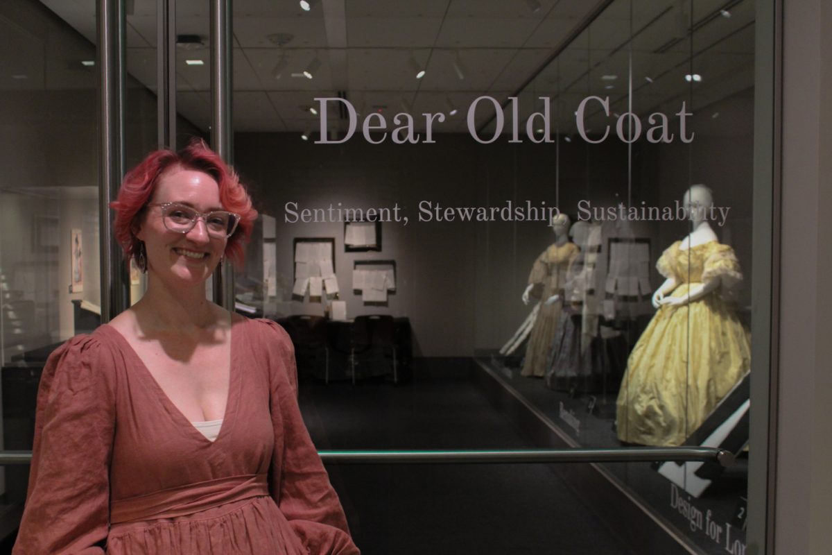 Rebecca Evans, curator of the exhibition "Dear Old Coat: Sentiment, Stewardship, Sustainability," stands beside the door of the Avenir Museum of Design and Merchandising’s Richard Blackwell Gallery Sept. 4. The exhibition will be on display in the gallery until Dec. 20.