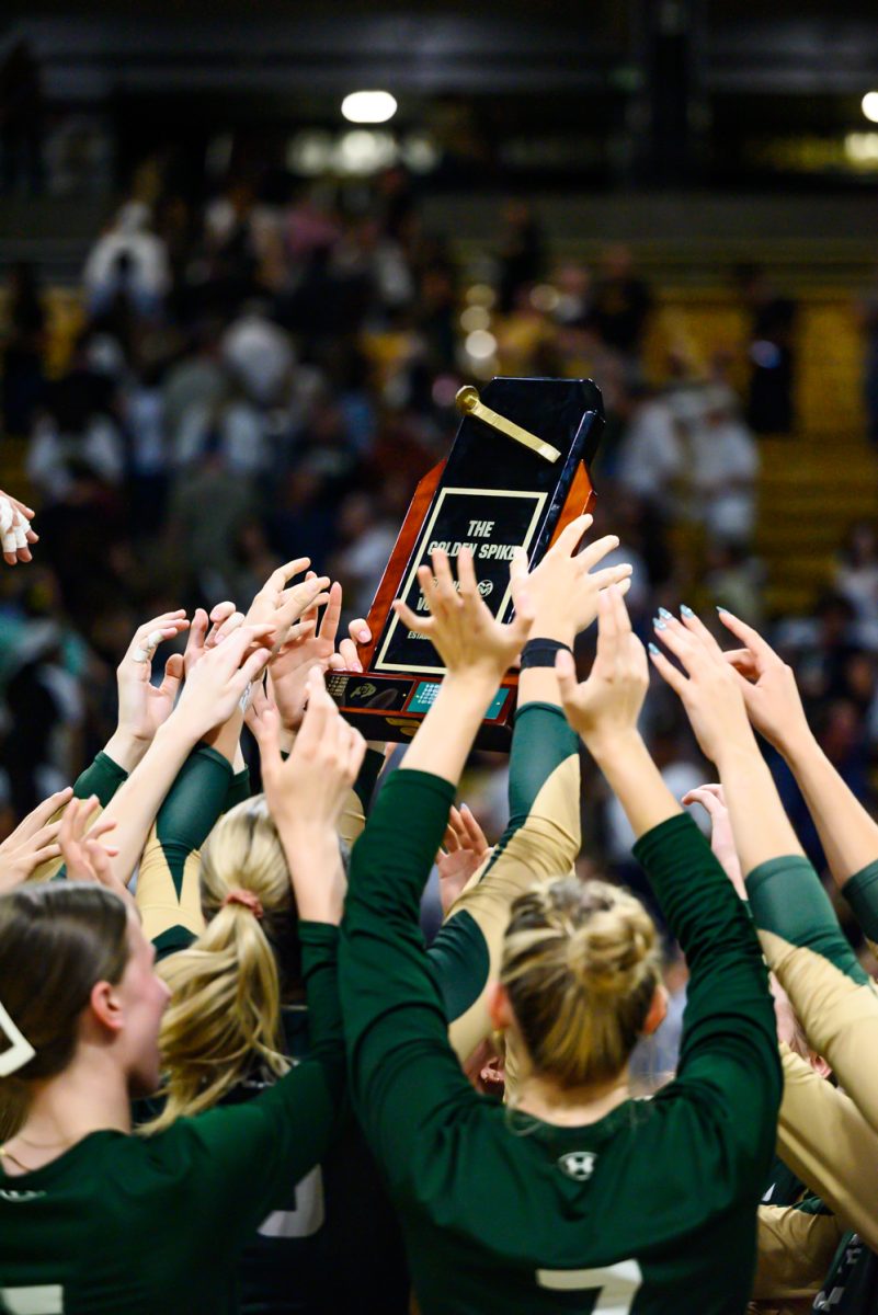 Colorado State University's volleyball team hoists the Golden Spike trophy after winning it from the University of Colorado Sept. 19. CSU won 3-1.