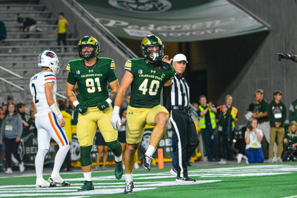 Two players in a green and gold jersey celebrating.