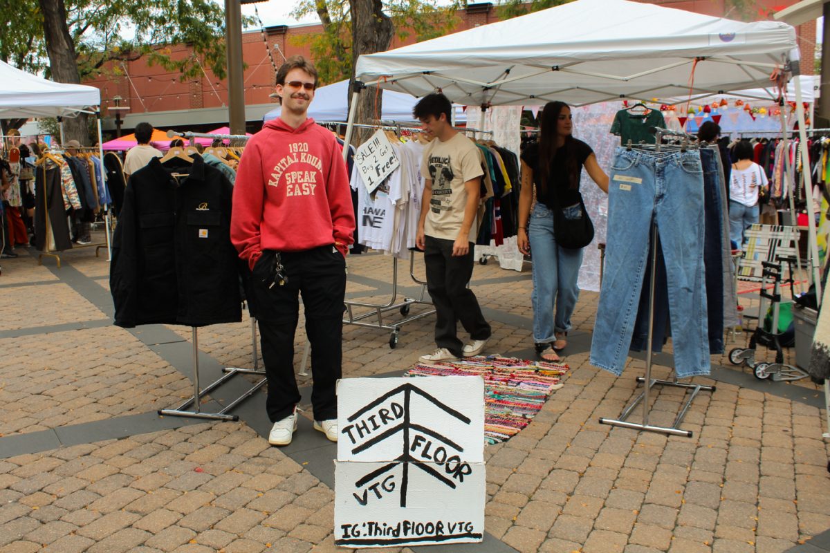 Jake Budzynski, owner of Third Floor Vintage poses for a photo with his booth at the Saturday Vintage Market Sept. 20. 