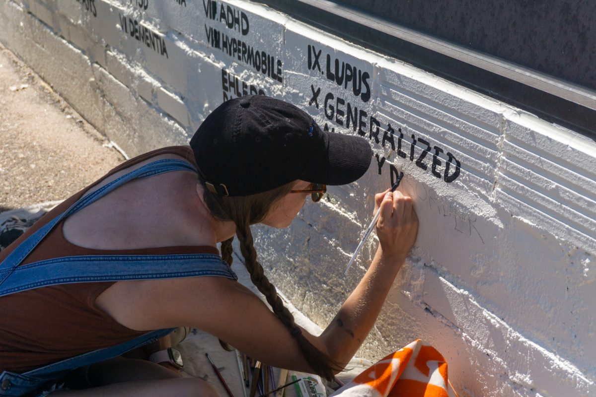Lydia Cruz works on her mural during WeldWalls Mural Festival in Greeley Sept 20. Her mural depicts ten dogs that represent disabilities. All of these disabilities are ones that myself, my family, or friends have," Cruz said. "I haven't seen a lot of disability represented in public art around here."