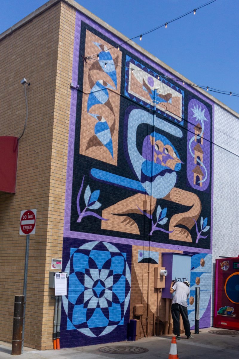Kevin Cincotta adds his name to his mural during WeldWalls Mural Festival in Greeley Sept 20. "This mural is meant to feel open," Cincotta said in the mural description. "...viewers can bring their own memories and experiences to it."