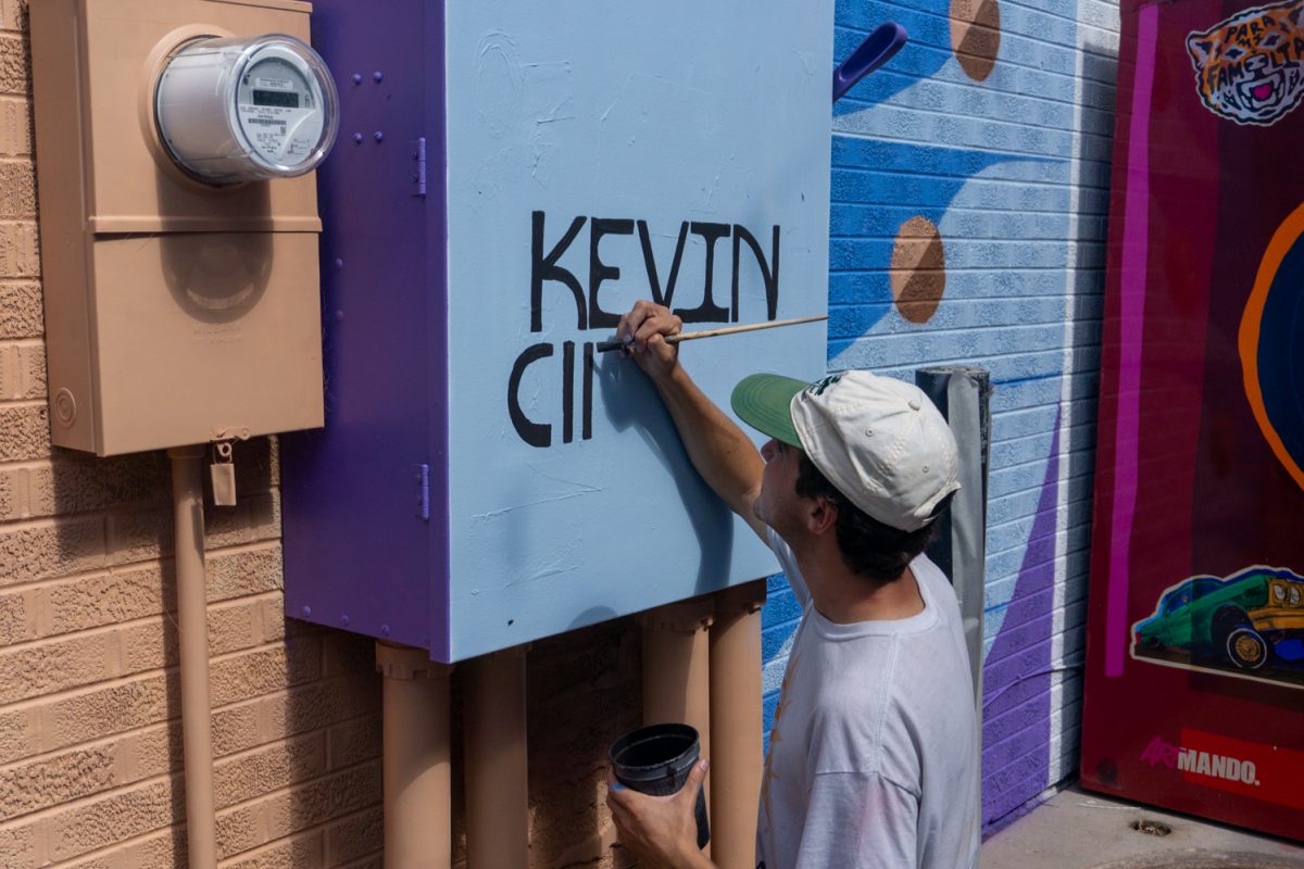 Kevin Cincotta adds his name to his mural during WeldWalls Mural Festival in Greeley Sept 20. "This mural is meant to feel open," Cincotta said in the mural description. "...viewers can bring their own memories and experiences to it."