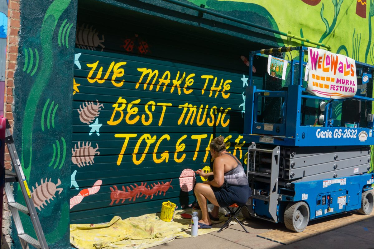 A member of Blackbox Art Collective work on their mural during WeldWalls Mural Festival in Greeley Sept 20. Weld Walls brings together artists to create publicly accessible murals, according to the website. The event includes artist talks, workshops, mural unveilings, and a community celebration.