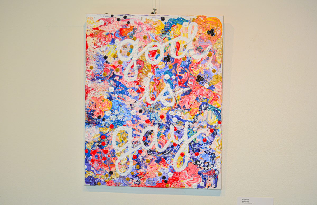 An acrylic painting by artist Riley Welsh titled "God is Gay" hangs in Colorado State University's Sideshow Gallery Sept. 25. This piece was a part of the "Off The Clock" exhibition.