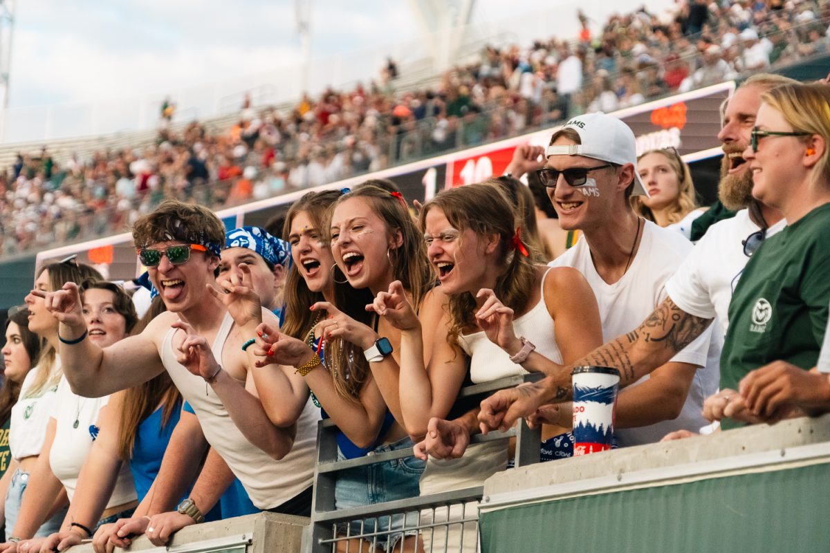 Students throw up the Ram hand sign as they cheer on the Colorado State University football team during the game against Washington State University Sept. 27. The white-out theme was in honor of CSU's annual State Pride game celebrating Colorado.