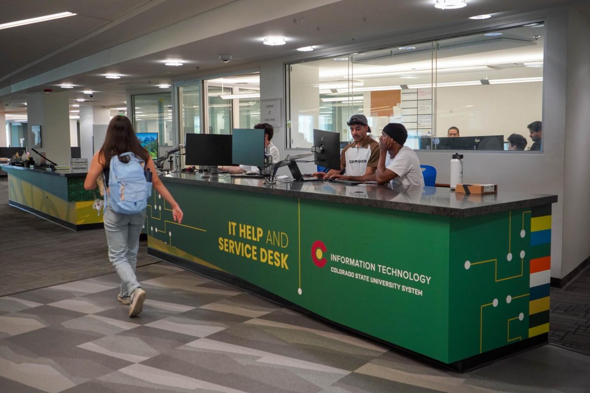 Student staff members sit at the Colorado State University Information Technology desk Sept. 15. The desk is located in the Morgan Library. 