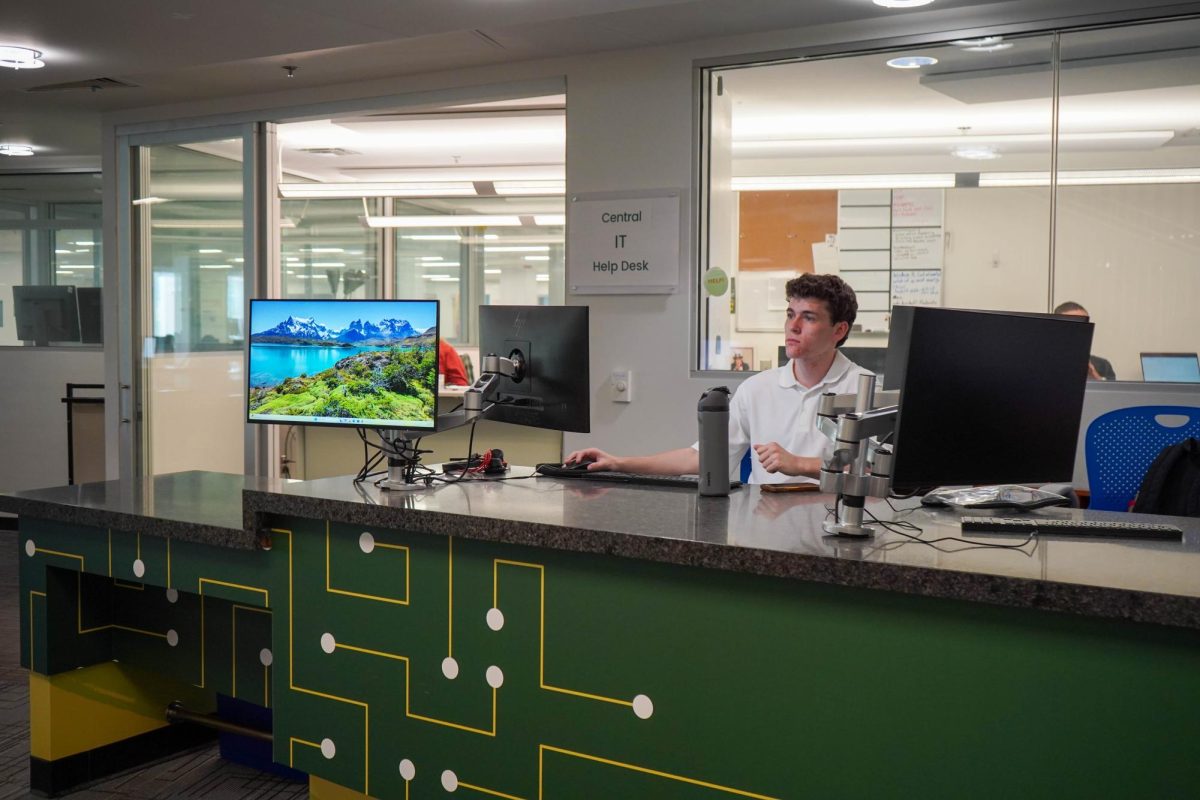 Student staff members sit at the Colorado State University Information Technology desk Sept. 15. The desk is located in the Morgan Library. 
