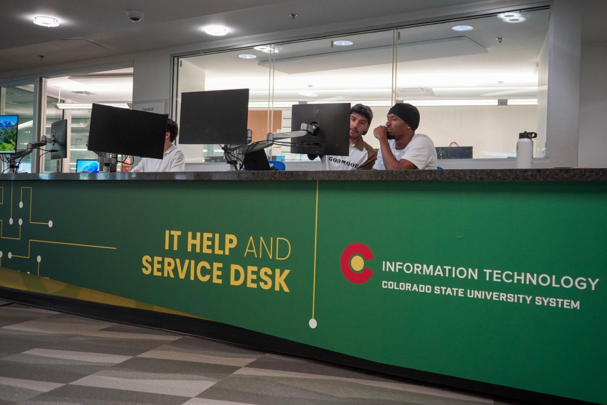 Student staff members sit at the Colorado State University Information Technology desk Sept. 15. The desk is located in the Morgan Library. 