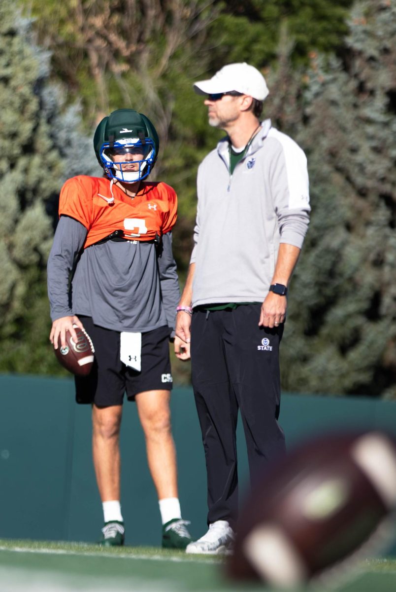Quarterback, Jackson Brousseau and coach Matt Mumme prepares for a drill during the Tuesday morning practice on Sept. 30th at Colorado State University in Fort Collins Colorado. Photo taken by Erica Pickering.