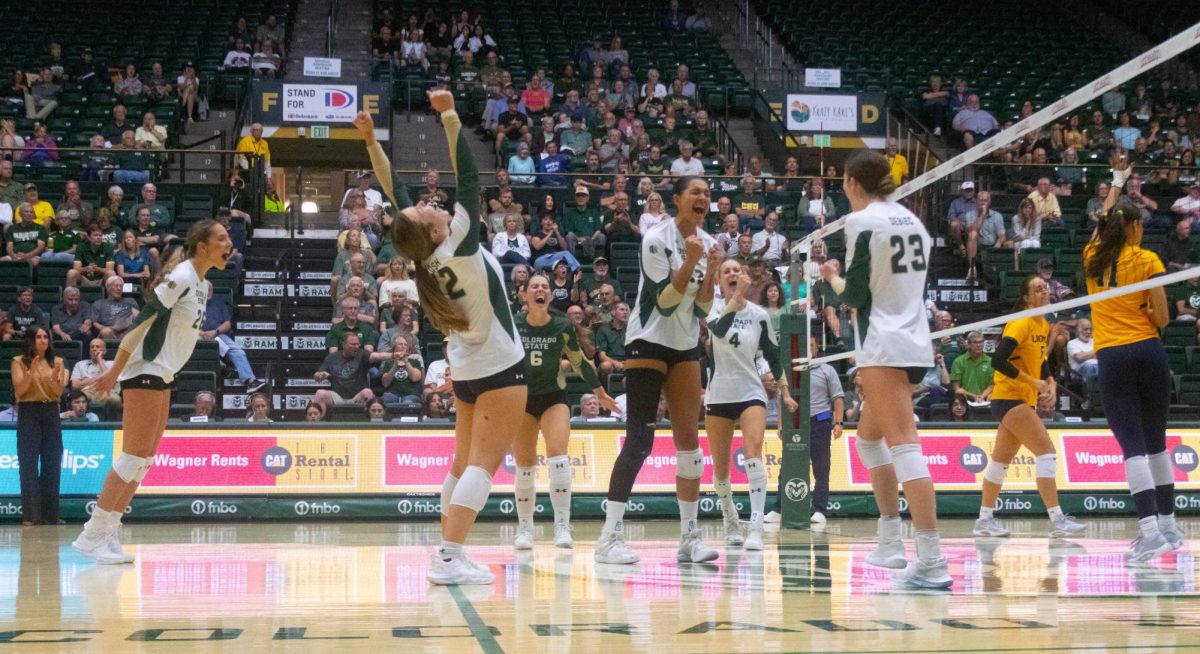 5 women in white jerseys and one in a green jersey yelling and clapping. One of them putting their hands in the air.