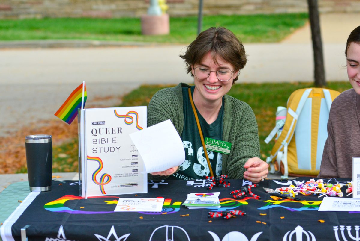 A girl in a green jacket putting down a piece of paper