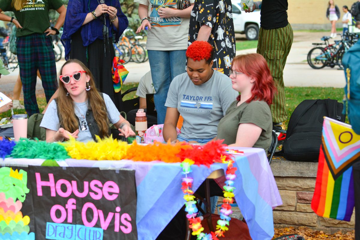 Three people at a colorful booth.