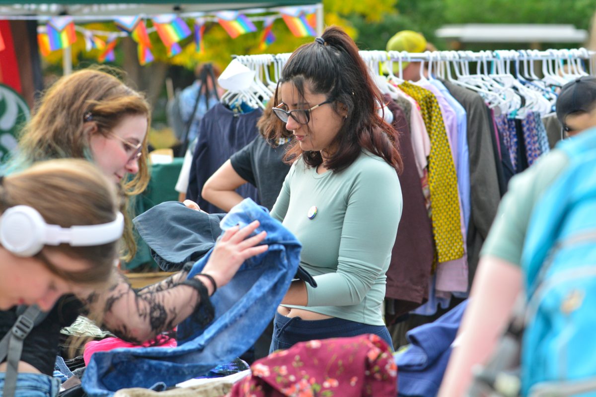 A girl in a mint color shirt folding clothes at an event.