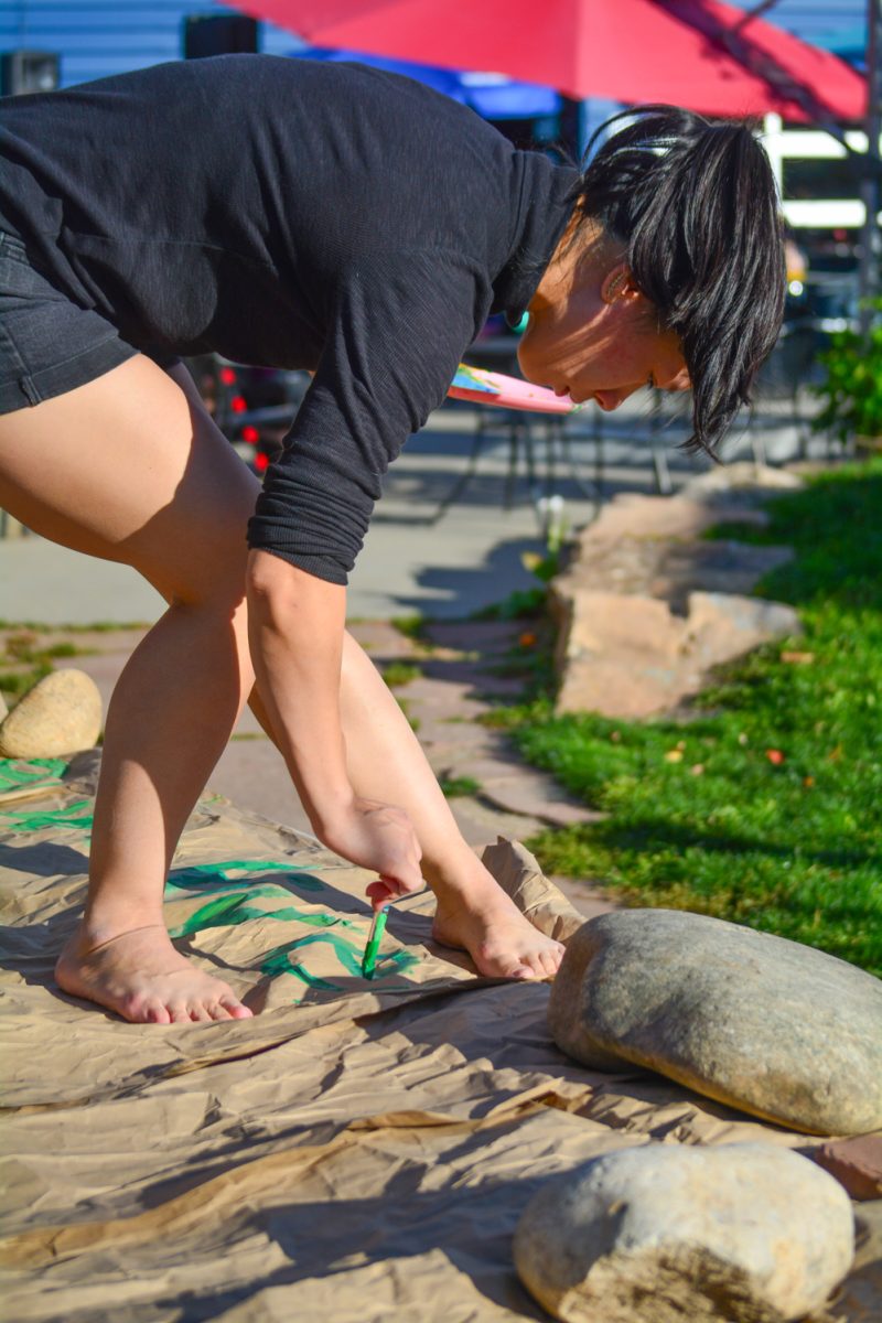 Maria Win Nguyen painting an interactive map for a childrens corner Oct. 19. This was an Alpine Arts Collective event at the Common Ground event held at the Lyric.