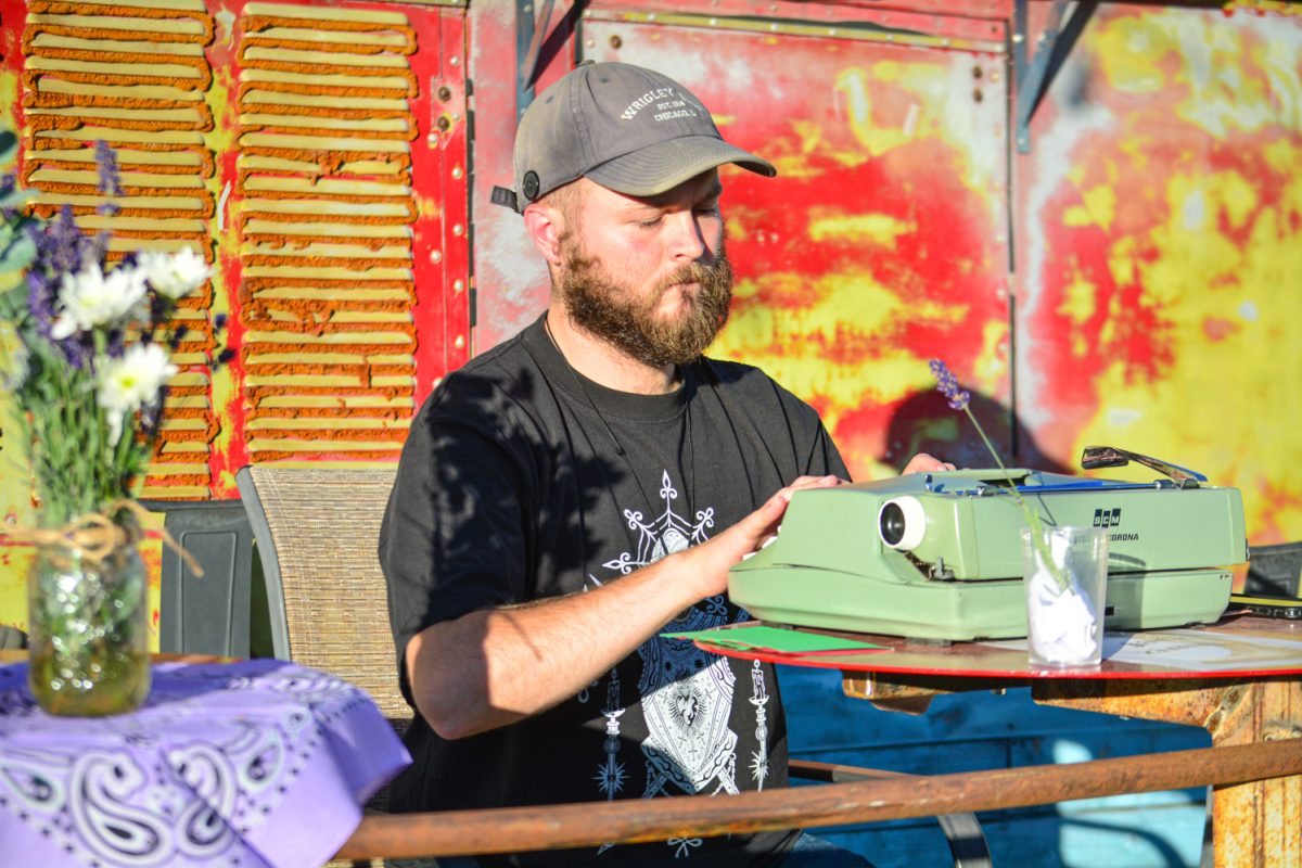 Jack Zimmer writes a poem on his typewriter at the Common Ground festival Oct. 19. "I usually just write poems based off words they give me," Jack said. "I think people just deserve to get a poem without having to worry about paying for it."