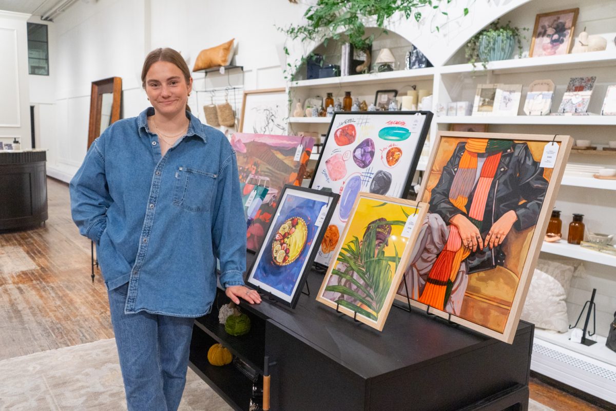 Artist Lydia Tarleton stands next to a table featuring her colorful, custom paintings being featured at Hutch Home Co. at the First Friday Art Walk Oct. 3. “I feel like it's putting my name out there," Tarleton said. "People have contacted me at later dates, and I've sold a lot of paintings that way." The First Friday Art Walk is an event happening every month in downtown Fort Collins, when businesses feature local artists in their stores as part of a collaborative art show.
