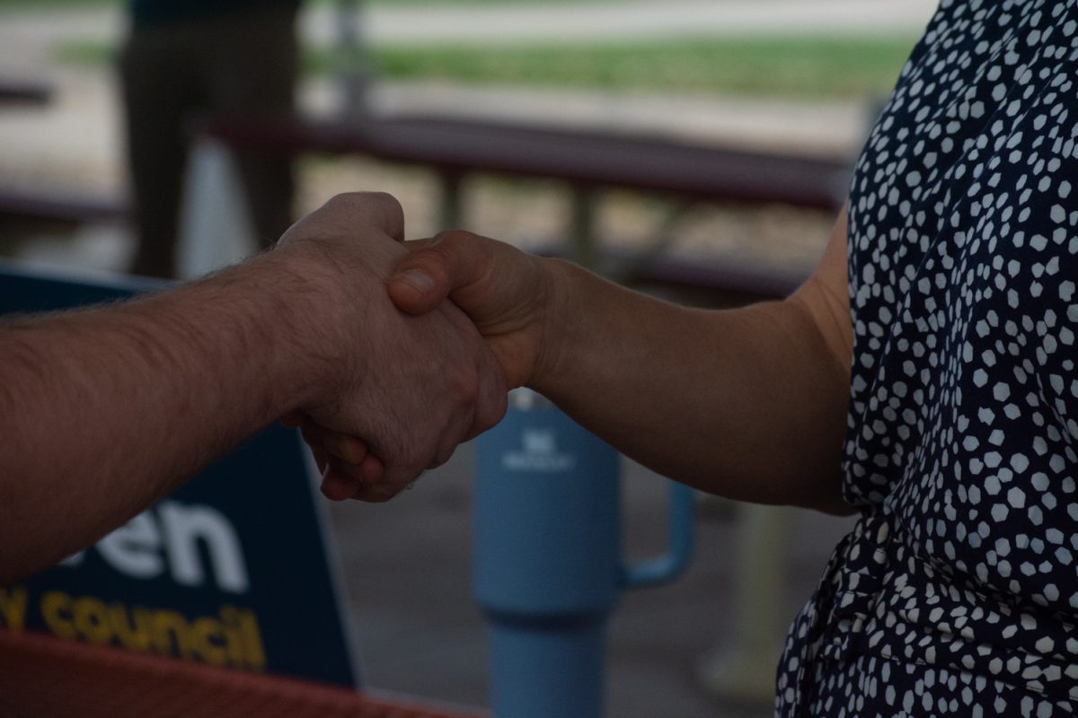 Emily Francis and Sam Hutton shake hands at Civic Saturday event Oct. 4. 