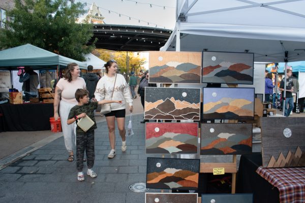 Emily Zolman and her son, Max, walk with visiting friend Leah Barr, who is from Wisconsin, viewing items on sale at the Moonlight Market’s business vendor booths at Old Town Square Fort Collins Oct. 17. “I wanted to try and give her the full Fort Collins experience," Emily Zolman said. "So we went shopping earlier today, and now we’re at the market."