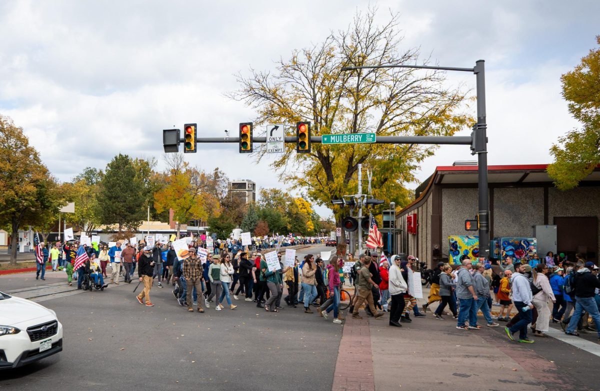 Thousands of protestors walk down a road.