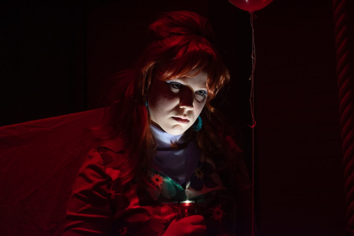 Colorado State University theater major and actor playing “Emily” in the Cherryfield Toy Company production performs a frightening scene with light shadowing her face in a red room during a dress rehearsal in the University Center for the Arts Oct. 20.