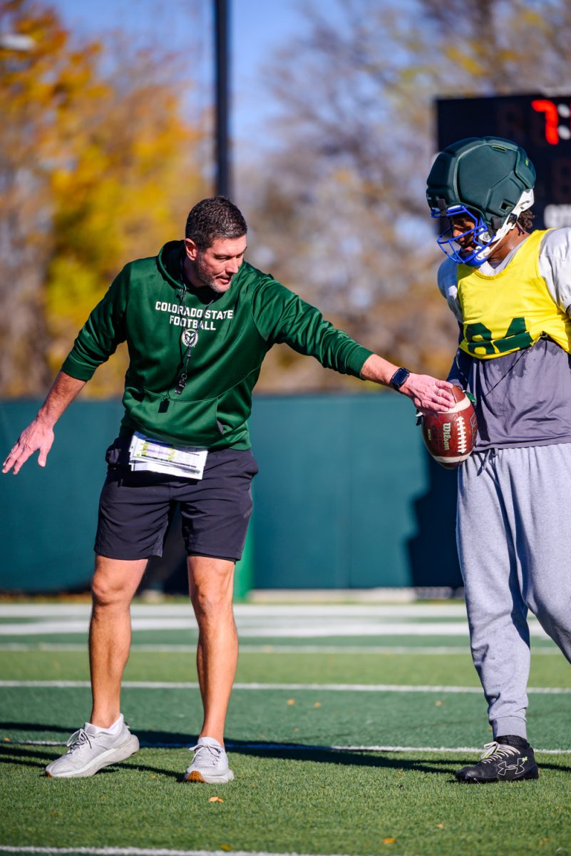 Colorado State University football tight end coach Grant Chesnut gives advice to wide receiver Stephon Daily (84) during football practice Oct. 21. 