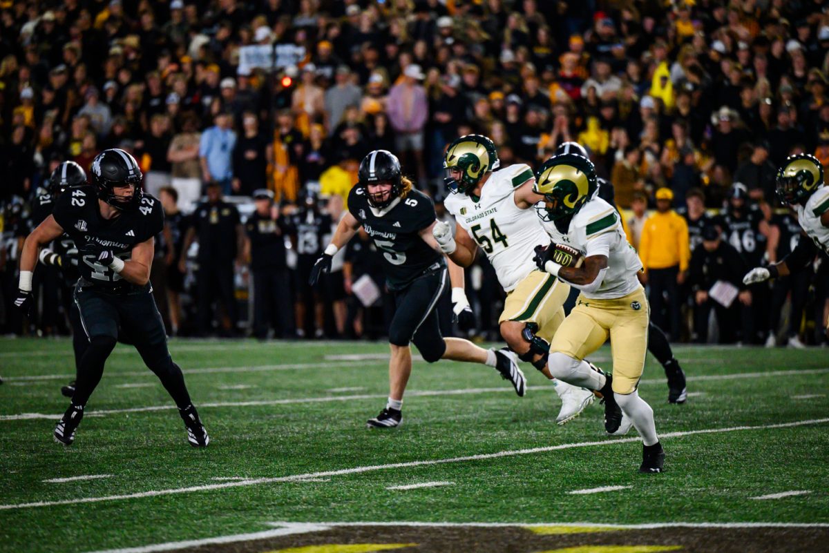 Colorado State University football running back Justin Marshall (20) takes the ball down the field against the University of Wyoming's defense Oct. 25.