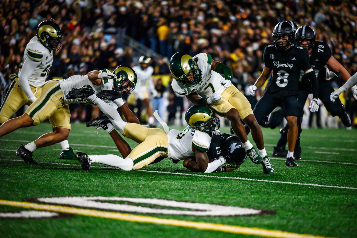 Colorado State University football defensive backs Chris Jackson (0) and Lemondre Joe (7) take down University of Wyoming wide reciever Chris Durr Jr. (13) during CSU's game against UW Oct. 25.