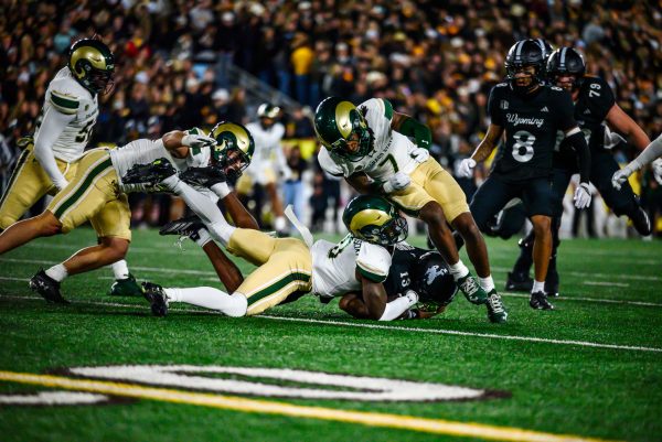 Colorado State University football defensive backs Chris Jackson (0) and Lemondre Joe (7) take down University of Wyoming wide reciever Chris Durr Jr. (13) during CSU's game against UW Oct. 25.