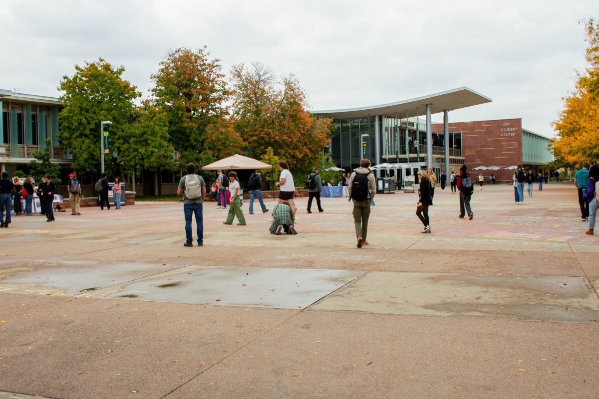 Students continue to chalk around puddles of washed away messages on The Plaza. Chalk messages were erased per a 2025 free speech policy update. 