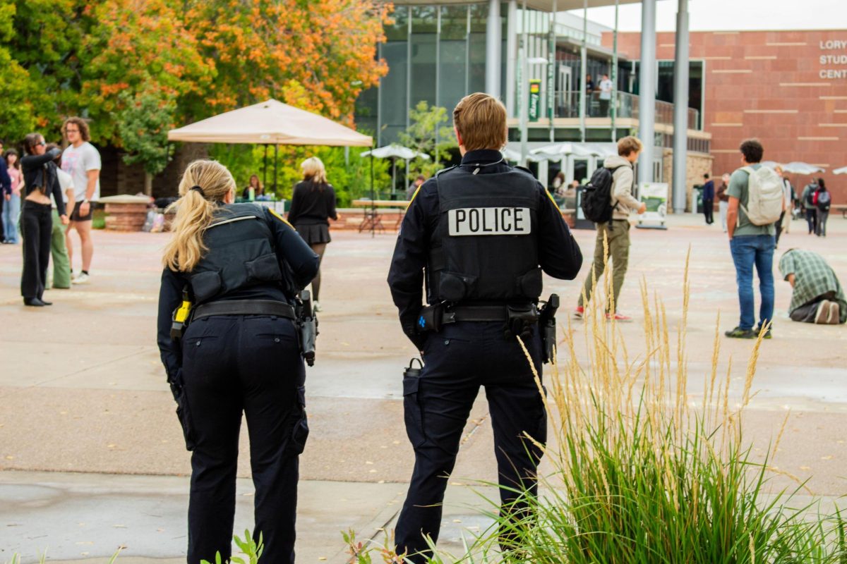 Colorado State University Police Department officers watch students chalk messages on The Lory Student Center Plaza Oct. 7. Chalk messages were erased per the 2025 Free Speech and Peaceful Assembly policy update.