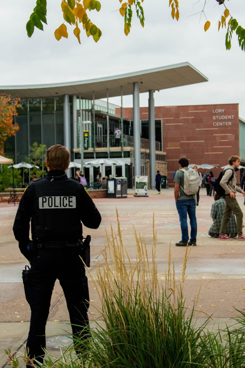 Colorado State University Police Department officers watch students chalk messages on The Lory Student Center Plaza Oct. 7. Chalk messages were erased per the 2025 Free Speech and Peaceful Assembly policy update. 