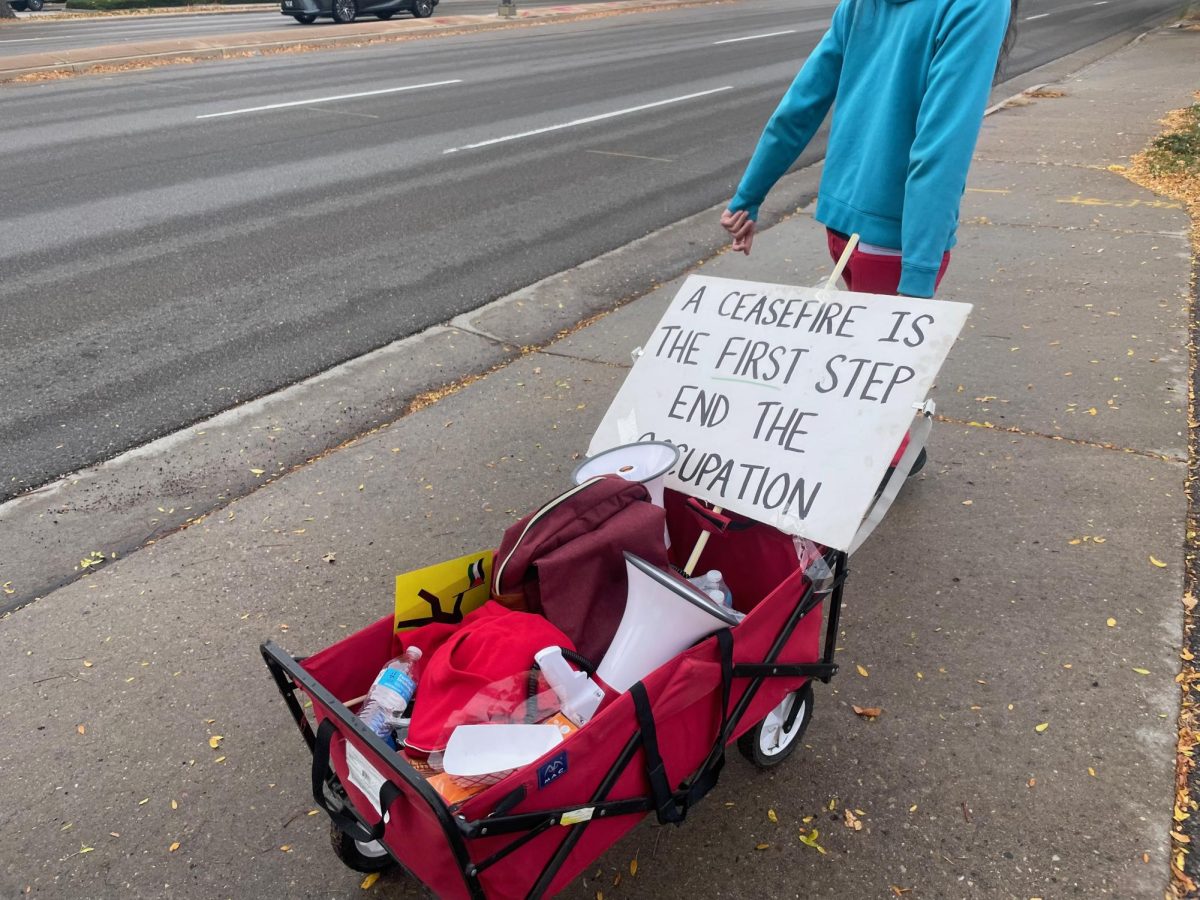 A demonstrator pulls a wagon of supplies and protest materials Oct. 11 leading a group of community members 14 miles down College Avenue to show solidarity with displaced Palestinians in the Israel-Hamas war. 