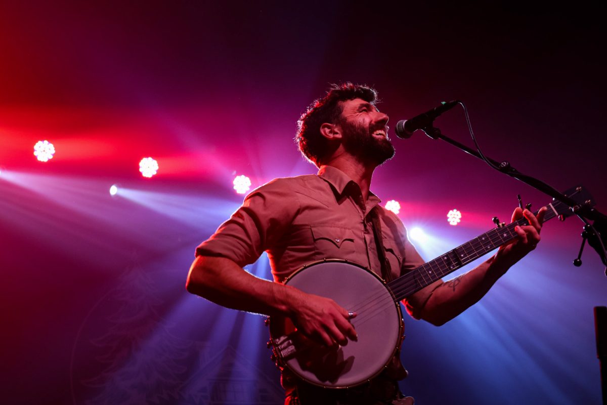 Ryan Acker sings and plays banjo with band The Last Revel at the Aggie Theatre Oct. 9. “Everyone is excited that the music between the bands really do compliment each other, whether its on the front end or the back end," Acker said. "I'm excited to just see what it feels like when it switches to have the crowd already fired up."  