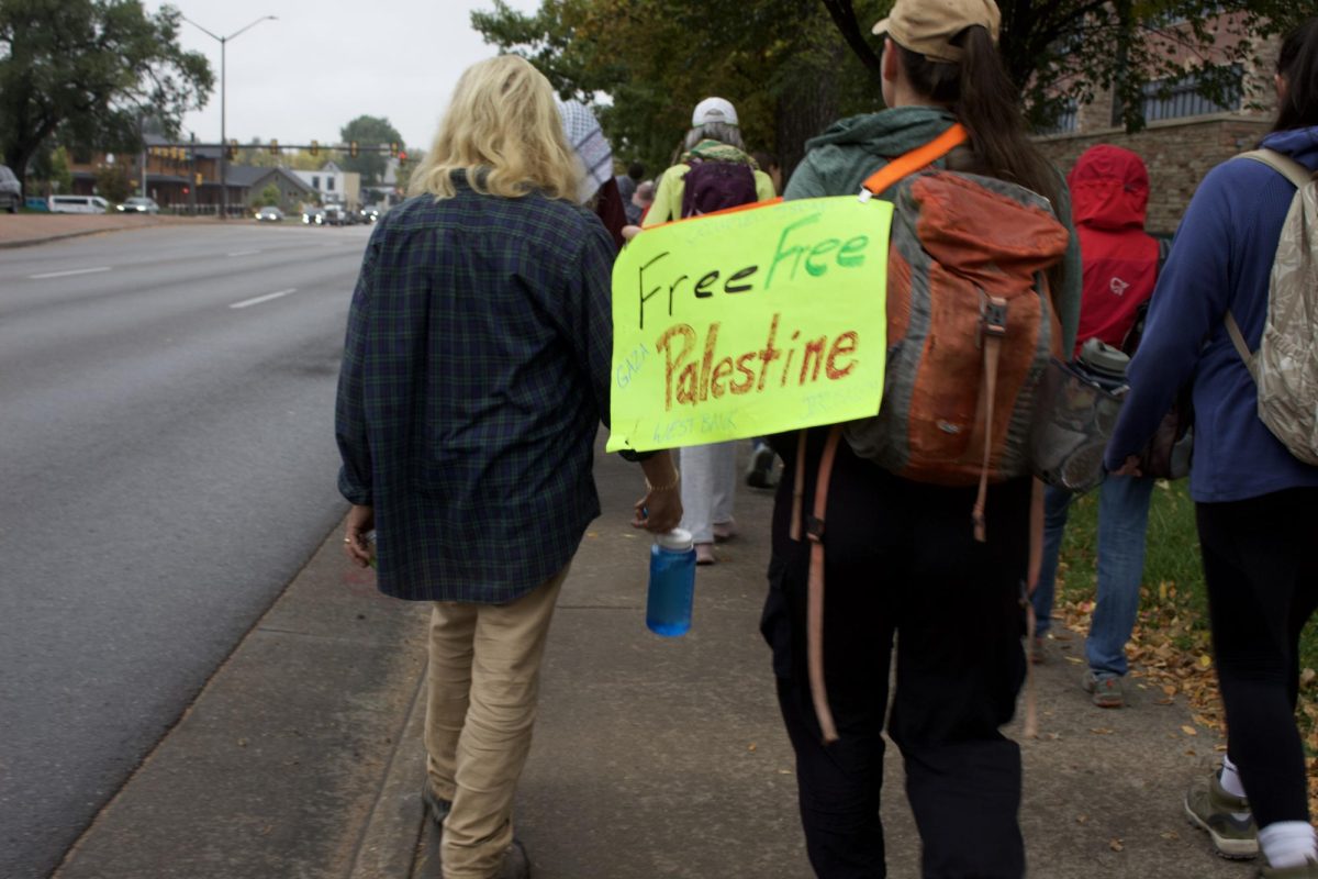 A demonstrator holds a sign that reads "Free Free Palestine" as they march along College Avenue in a 14 mile walk to show solidarity with displaced Palestinians Oct. 11.