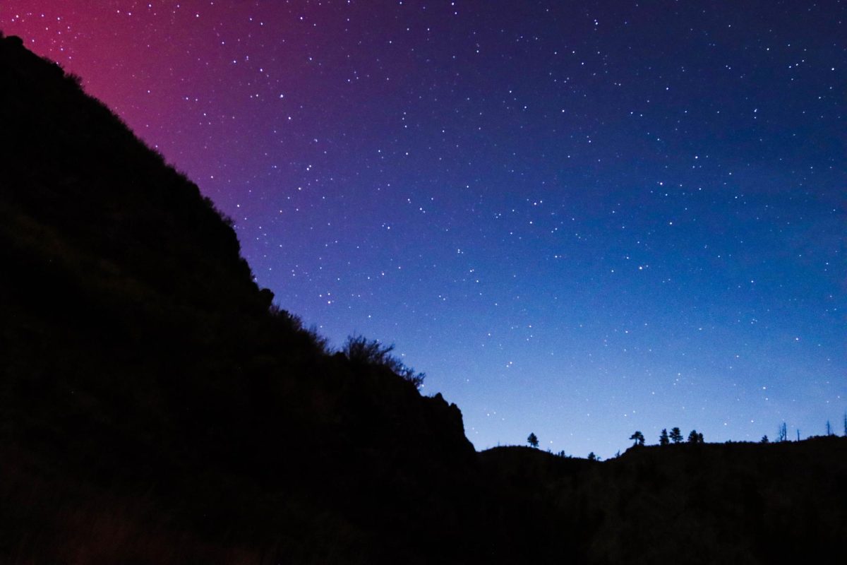 The Northern Lights dance across the sky of the Poudre Canyon in hues of blue and purple around Picnic Rock on November 11, 2025. (Katie Fisher | The Collegian). 