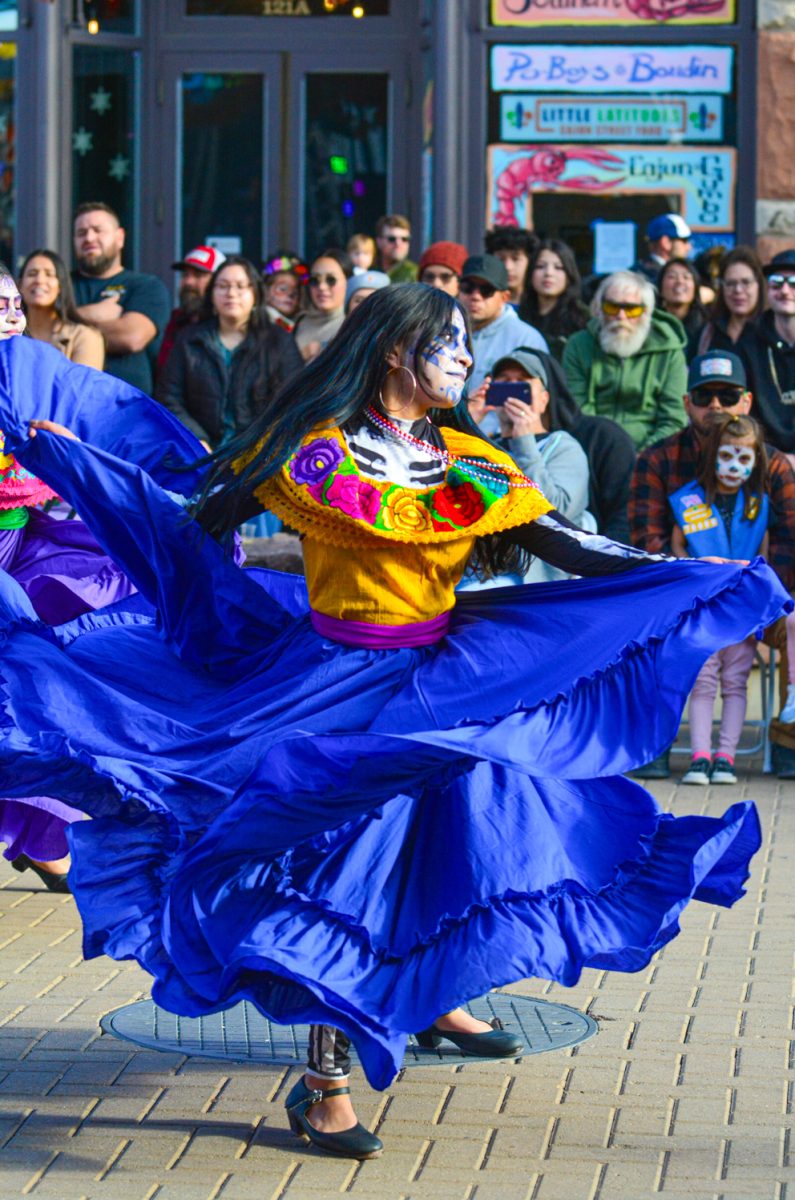 A dancer in skull makeup and a vibrant dress performs a traditional dance in Old Town Square during Día de Muertos Nov. 1.
