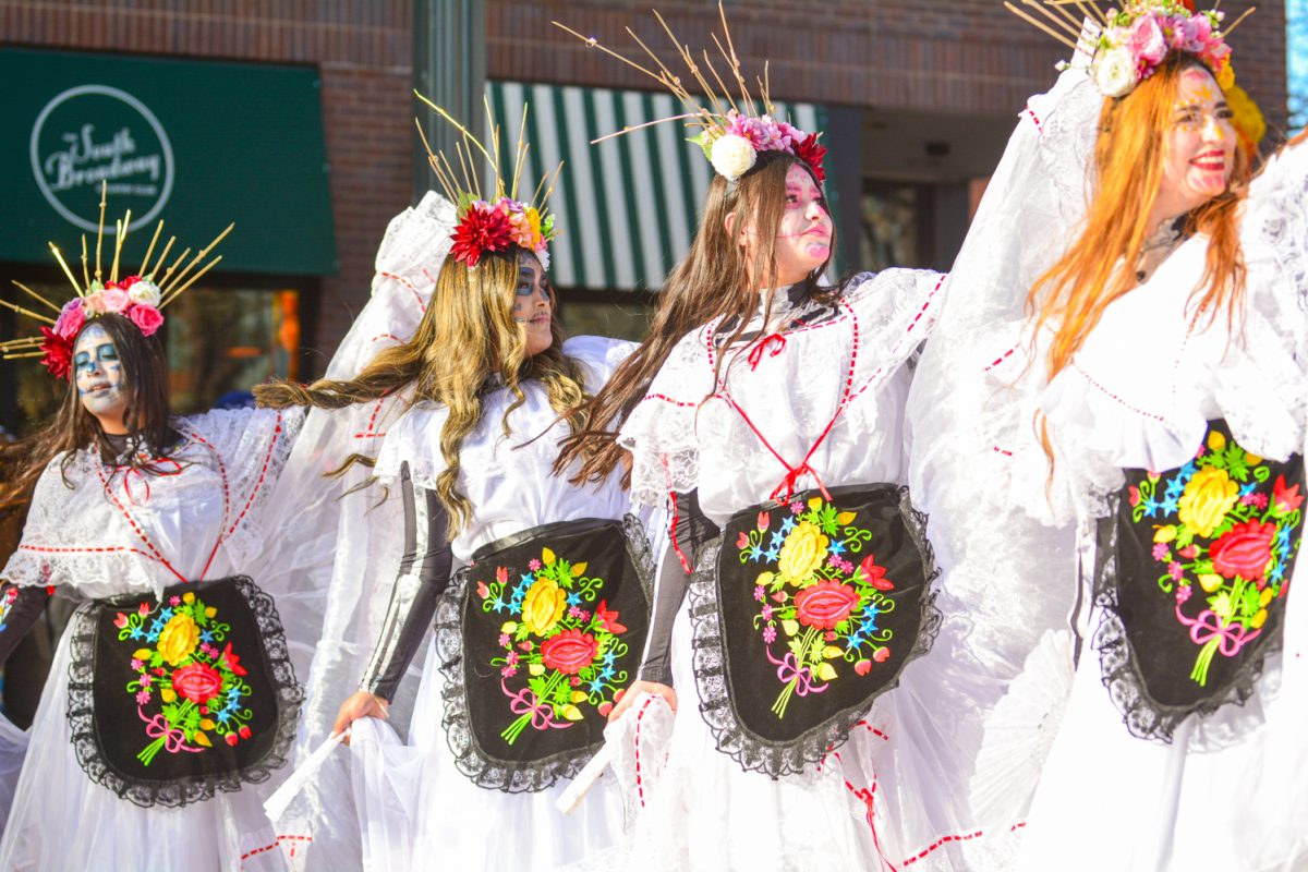 Four dancers with colorful flower headdresses perform a traditional Mexican dance to celebrate Día de Muertos Nov. 1. Their faces were painted with intricate calavera makeup representing sugar skulls, honoring the dead in a festive celebration. 