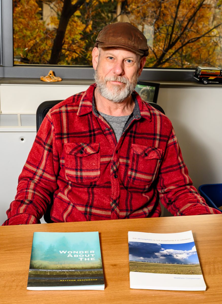 Colorado State University Professor and author Matthew Cooperman poses for a portrait with his published books in his office Nov. 3.